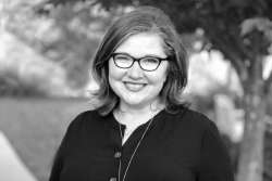 black and white photo of Kristin Stultz Pressley wearing glasses and smiling